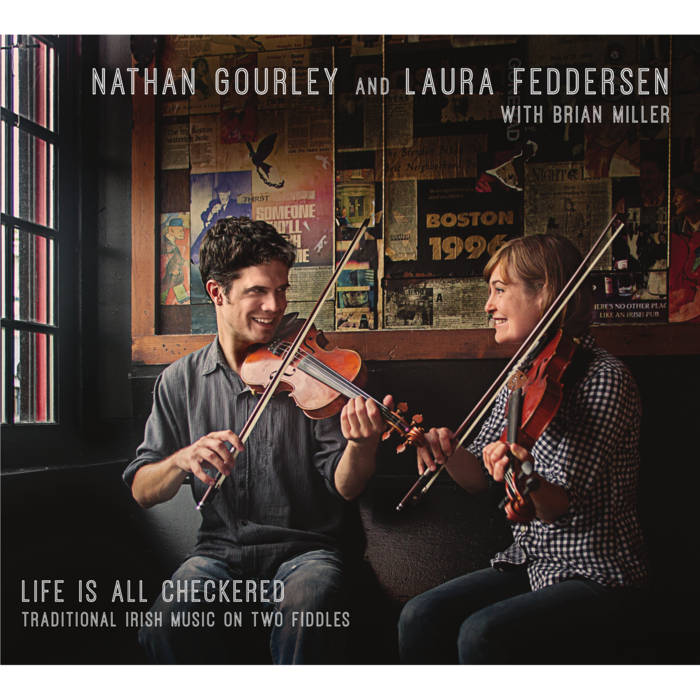 A man and a woman, both playing fiddle, smile at each other from the corner of a pub. The wall is plastered with clippings from Boston newspapers